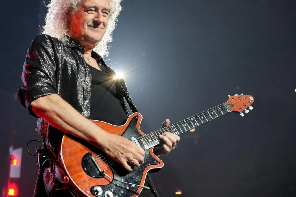 Brian May performing live on stage with his Red Special guitar.