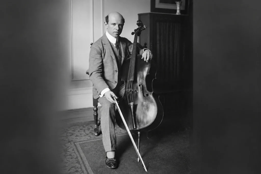 Cellist Pablo Casals seated with his cello in a historic black-and-white photograph.