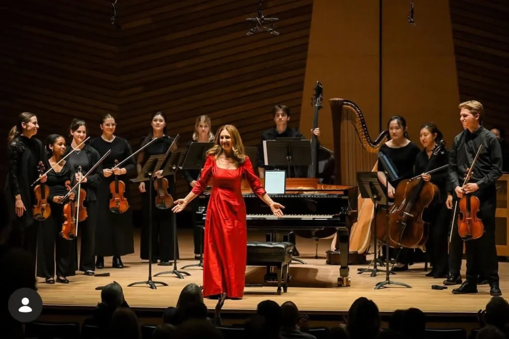 Pianist Simone Dinnerstein on stage with a classical ensemble following a live performance.